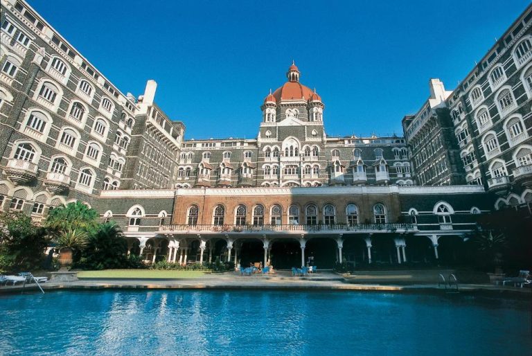 Piscina exterior con vistas a la fachada histórica del The Taj Mahal Palace Hotel en Bombay, India