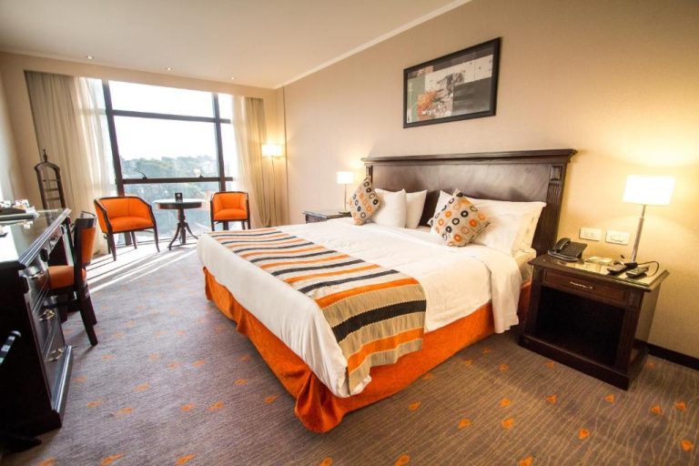 Habitación deluxe con cama king size y decoración en naranja del Carnaval Hotel Casino