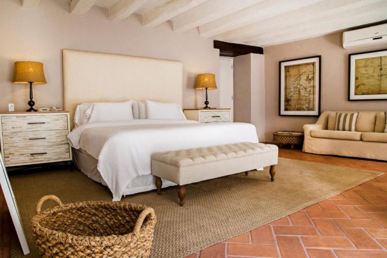 Habitación suite con cama doble y decoración colonial del Hotel Casa Don Sancho By Mustique en Cartagena
