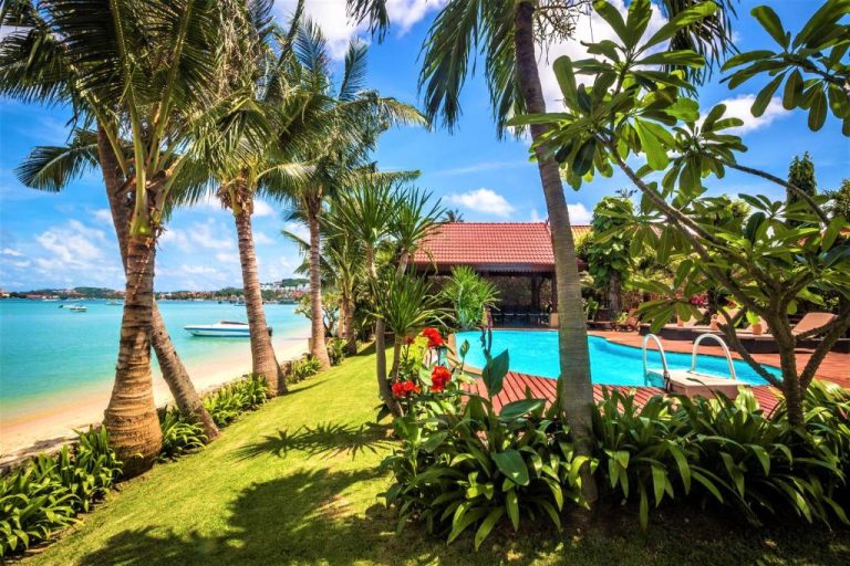 Piscina exterior con vistas al mar y jardín tropical en Erawan Villa Hotel frente a la playa