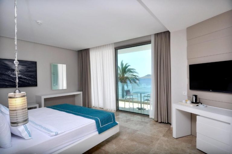 Habitación doble con cama king y vistas al mar con palmeras en Lugga Boutique Hotel & Beach