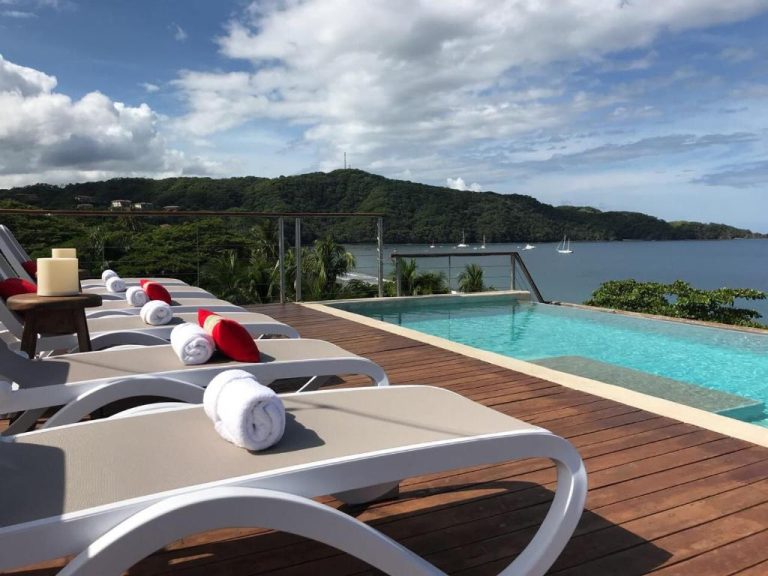 Piscina infinita con tumbonas y vistas al mar en Hotel La Gaviota Tropical Costa Rica
