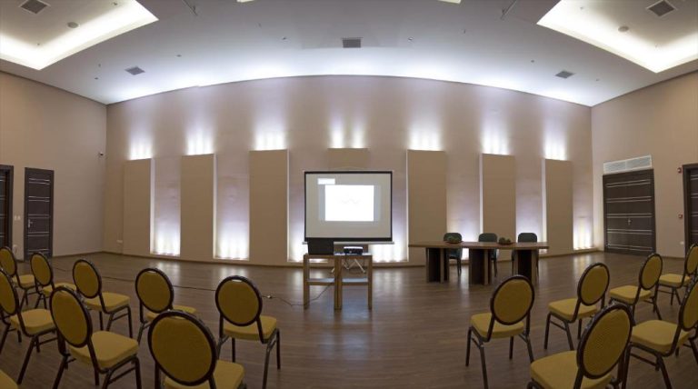 Sala de conferencias con proyector y sillas amarillas del Awa Resort Hotel, ideal para eventos