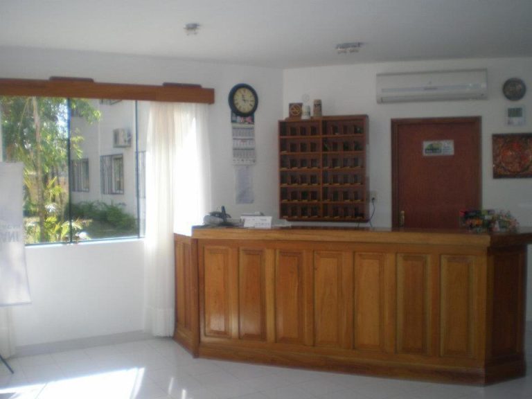 Recepción principal con mostrador de madera y casilleros del Hotel Ruta del Sol