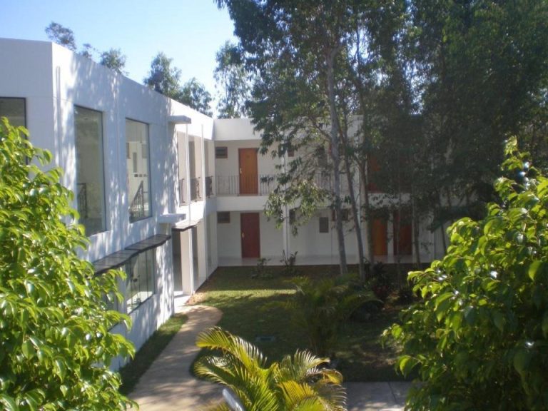 Jardín exterior con bungalows de dos plantas y vegetación tropical en Hotel Ruta del Sol