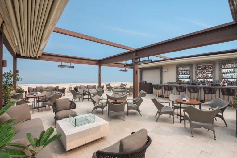 Terraza bar al aire libre con zona lounge y vistas al horizonte en The Oberoi New Delhi