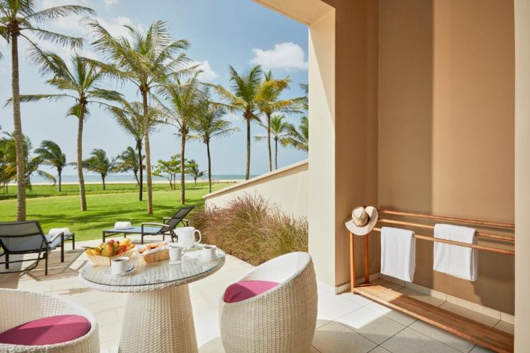 Terraza con mesa de desayuno y vistas al mar y palmeras en Sentido Heritance Negombo