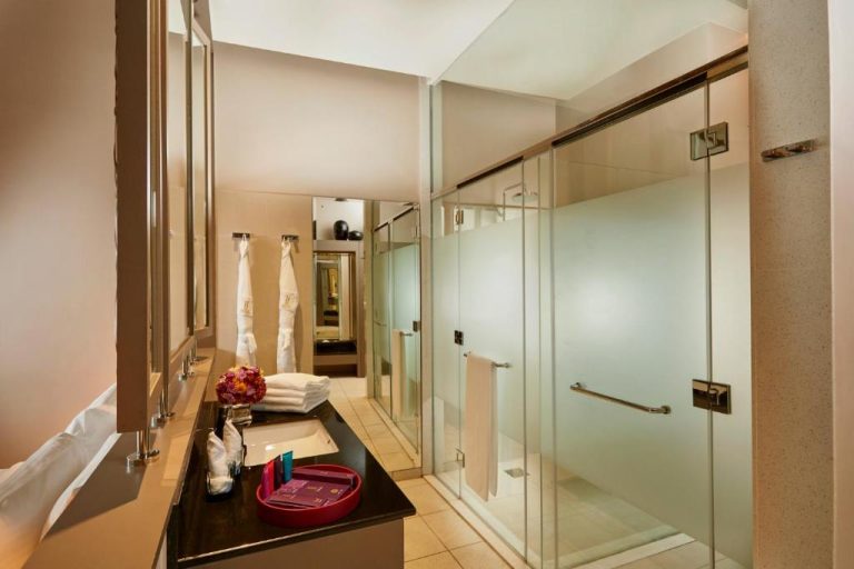 Baño de lujo con ducha de cristal y lavabo en el hotel Sentido Heritance Negombo de Sri Lanka