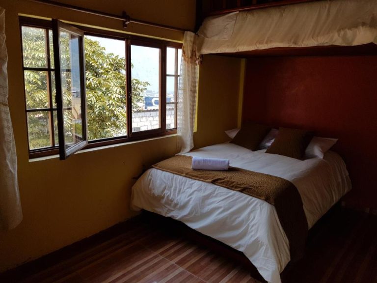 Habitación doble con cama matrimonial y ventana con vista exterior en Hotel Fuentes del Volcán