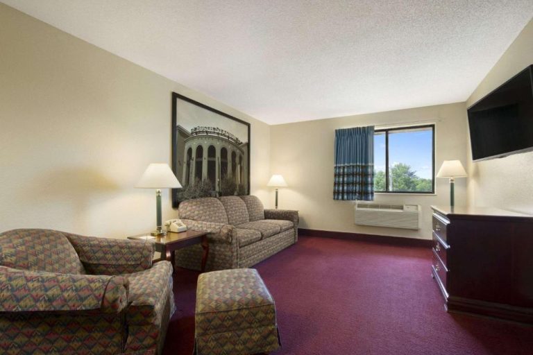 Sala de estar amplia con sofá, sillones y TV en suite del Super 8 by Wyndham Cuba