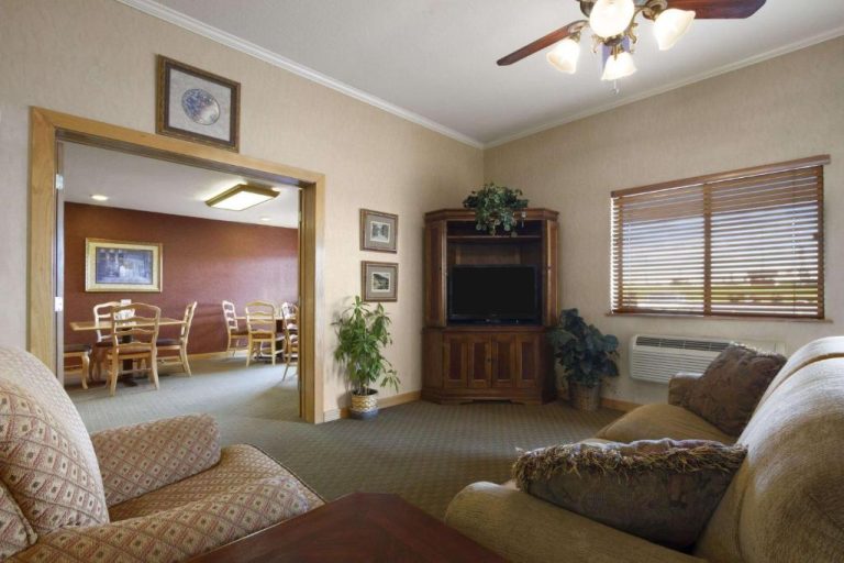 Sala de estar con sofás, televisión en esquinero de madera y comedor en Super 8 by Wyndham Cuba