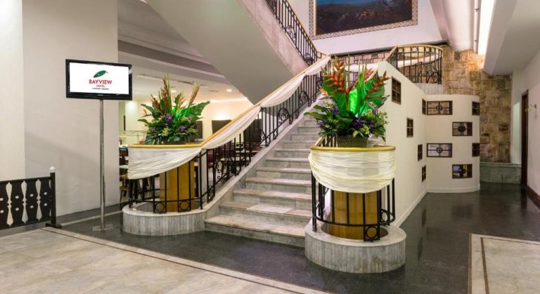 Elegante lobby con escalera principal decorada con flores tropicales en el Bayview Hotel Langkawi