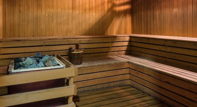 Sauna de madera con piedras volcánicas y cubo de agua del Bayview Hotel Langkawi