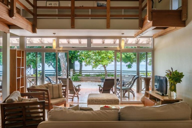 Amplia sala de estar con terraza y vistas al mar en el Hotel Fleur de Sel, con sofás y muebles de madera