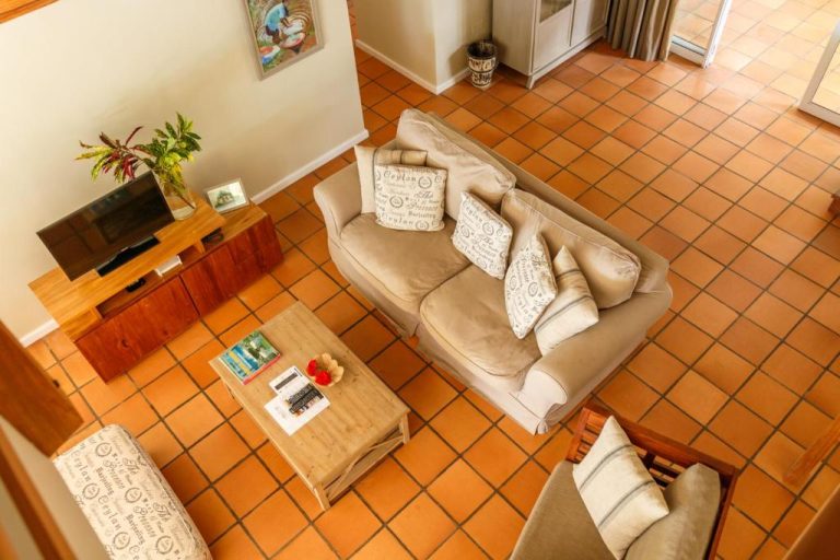 Sala de estar del Hotel Fleur de Sel con sofá, suelo de terracota y televisión desde vista aérea