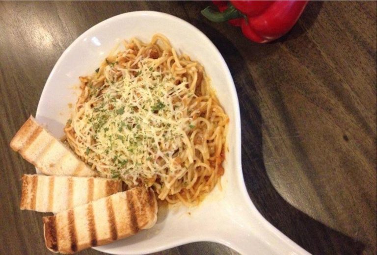 Plato de espagueti con queso rallado y pan tostado en el restaurante del Pillows Hotel Cebu