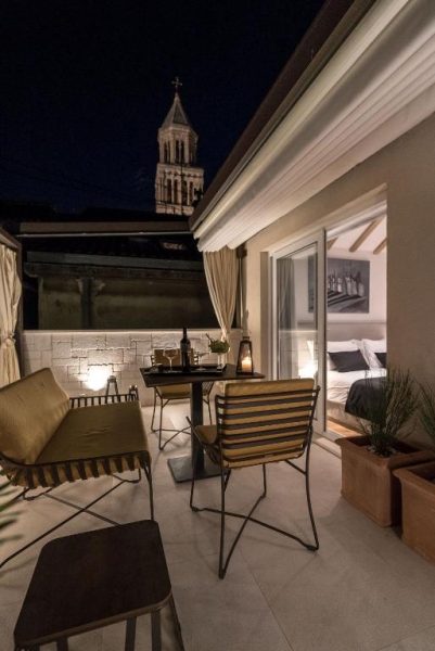 Terraza privada nocturna con vistas a la torre de la catedral en Murum Heritage Hotel Split