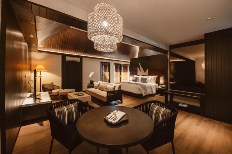 Suite de lujo con cama doble, sala de estar y lámpara de ratán en The Vira Bali Boutique Hotel