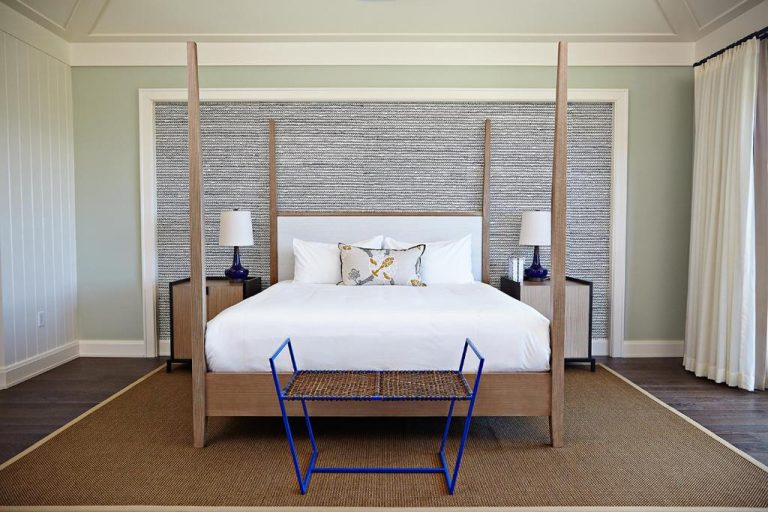 Habitación con cama de dosel de madera y cabecero tapizado en The Island House