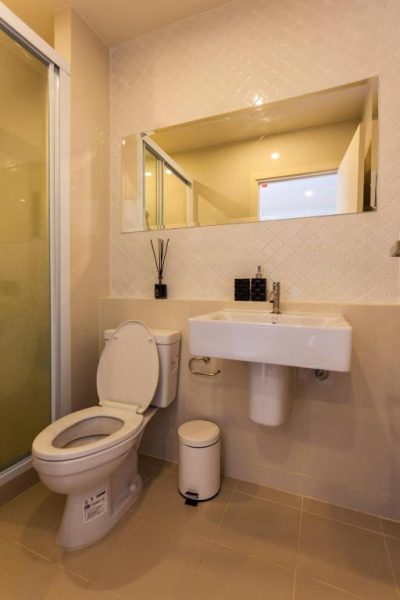 Baño moderno con ducha, inodoro y lavabo en condo de lujo The Base Downtown Phuket Town