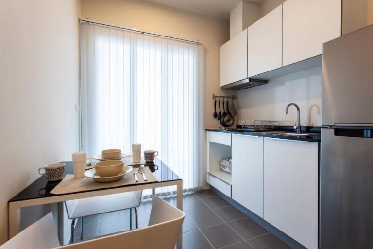 Cocina moderna con zona de comedor equipada en The Base Downtown Phuket Town Condo de lujo