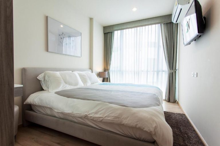 Habitación doble con cama king size y ventanal en The Base Downtown Phuket Town Condo
