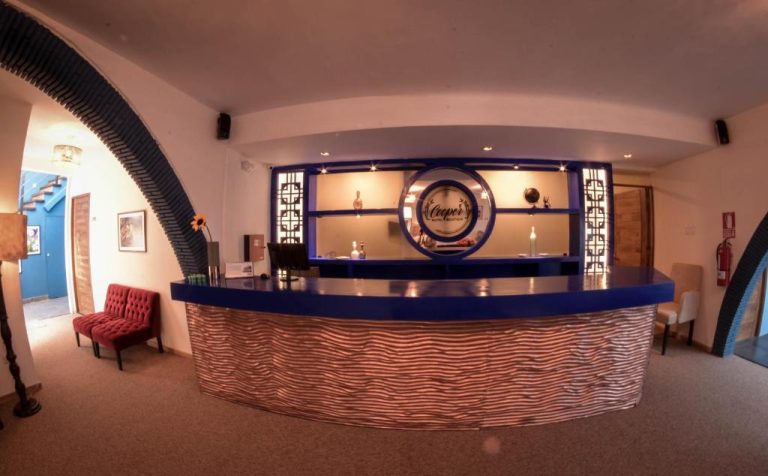Recepción principal con mostrador azul y decoración moderna del Cooper Hotel Boutique