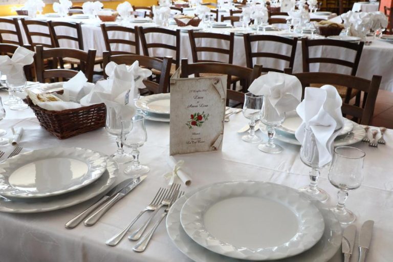 Elegante salón de banquetes para bodas con mesas decoradas en blanco en el restaurante Le Tre Rose