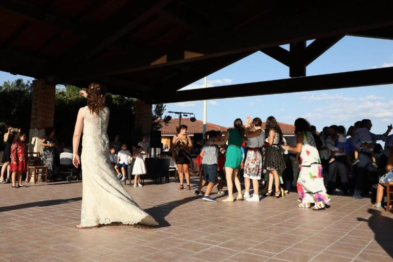 Invitados bailando en la pista exterior durante una boda en Le Tre Rose con novia en primer plano