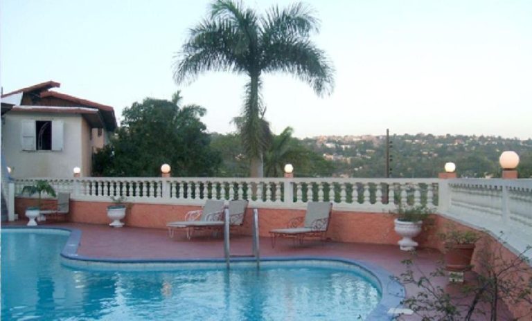 Piscina exterior con tumbonas y palmeras tropicales del Verney House Resort con vistas panorámicas