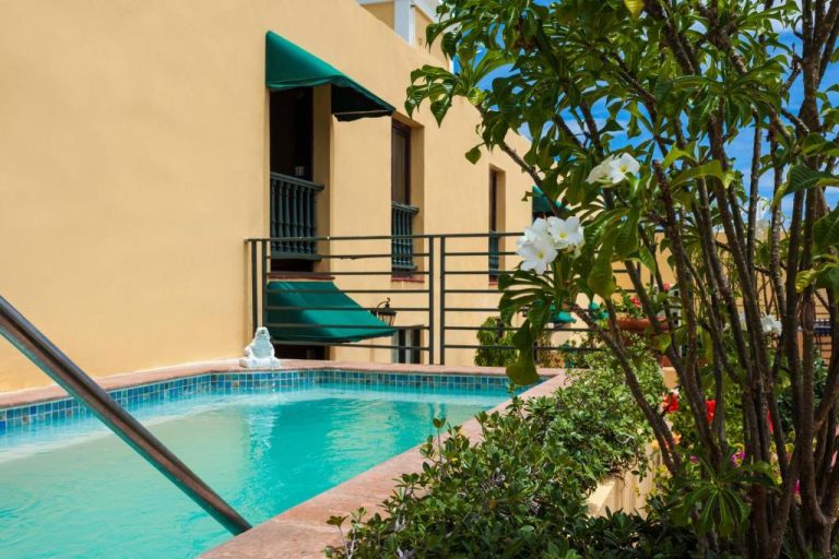 Piscina exterior con jardín tropical y balcón colonial del Hotel El Convento