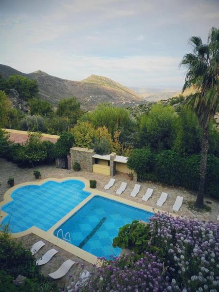 Piscina exterior con tumbonas y vistas a las montañas del Auberge des Cascades Imouzzer en Paradise Valley