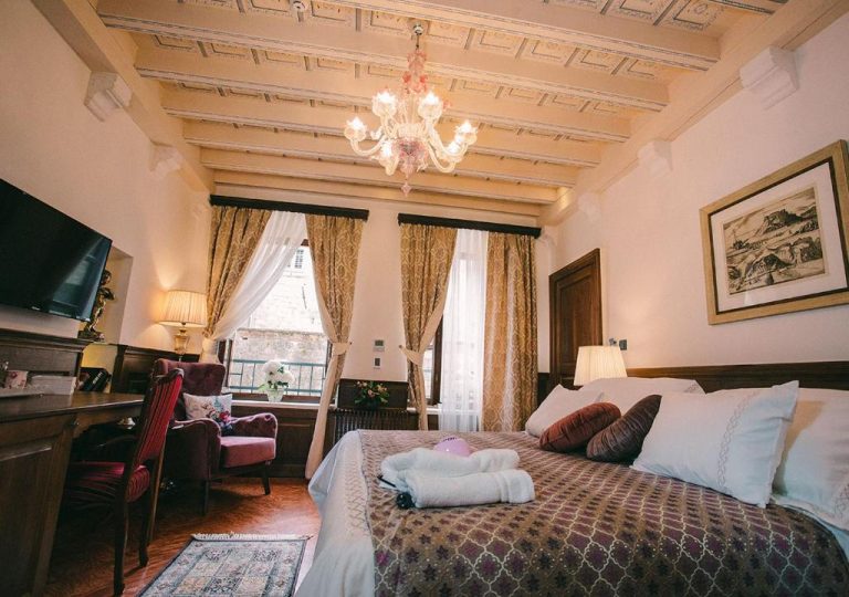 Habitación clásica con cama doble, techo artesonado y lámpara de cristal en Heritage Hotel Cardo