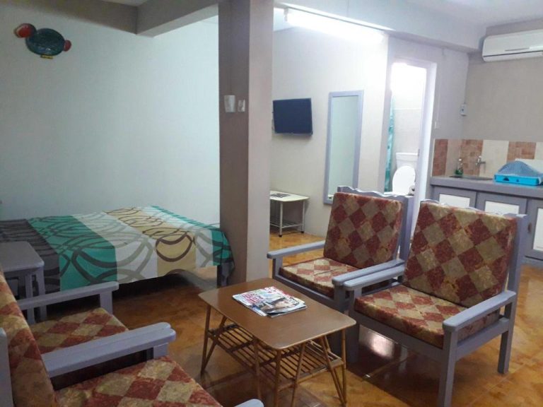Estudio del Centraville con cama, sillones tapizados, mesa de centro y zona de cocina integrada