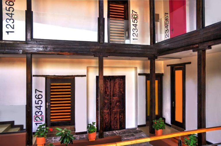 Patio interior colonial con puertas talladas y vigas de madera del Hotel Casa Gardenia