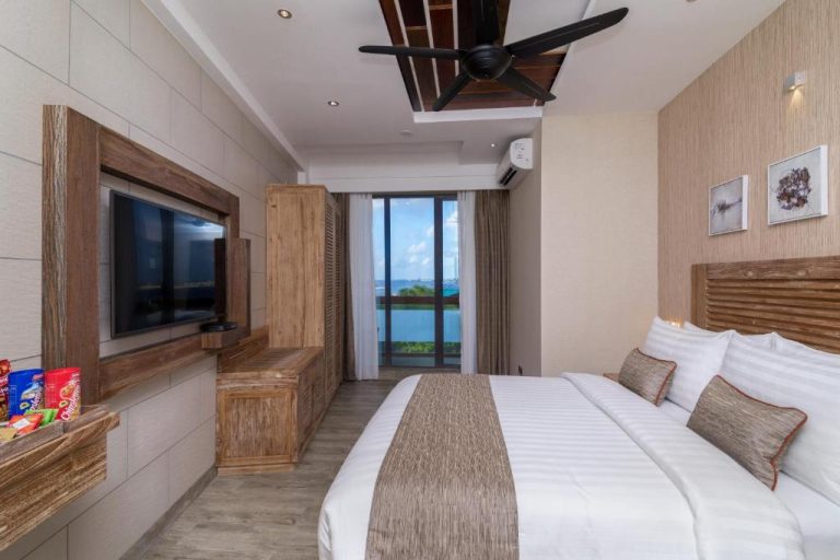 Habitación de lujo con cama doble, televisión y vista al mar en el hotel Samann Grand Maldivas