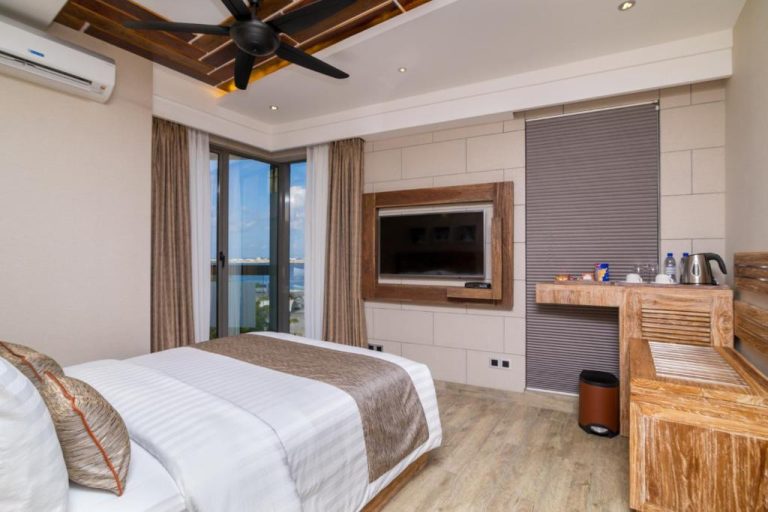 Habitación deluxe con cama doble, TV y vistas al mar en el hotel Samann Grand Maldivas