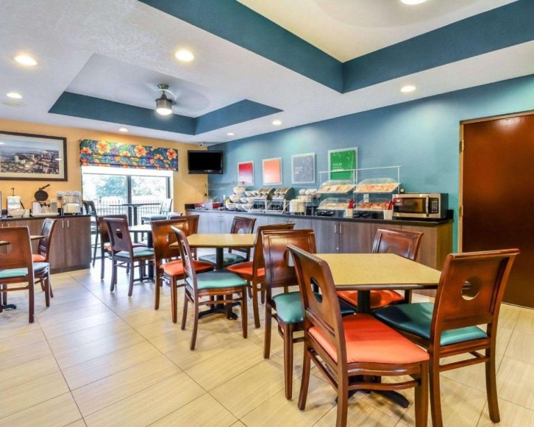 Sala de desayuno buffet con mesas y sillas coloridas en Comfort Suites Tampa Brandon