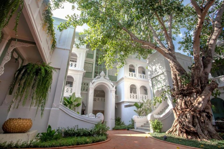Fachada colonial blanca con jardín y árboles frondosos del hotel boutique The Inside House