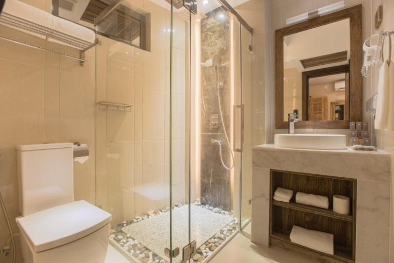 Baño moderno con ducha de cristal y lavabo de mármol en el hotel Samann Grand