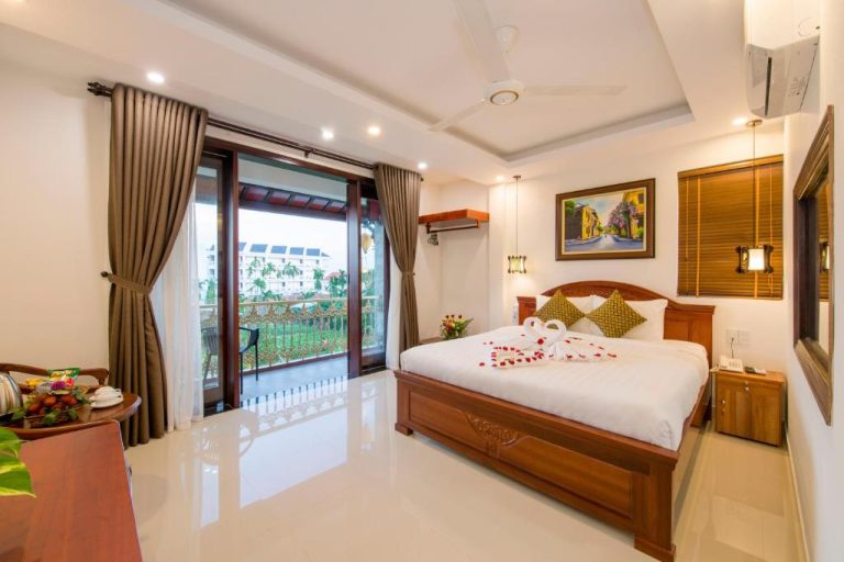 Habitación doble con cama king, decoración floral y balcón con vistas en Bonsai Villa Hoi An