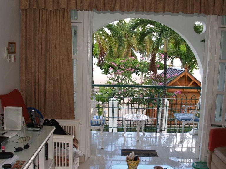 Salón con terraza y jardín tropical con palmeras en Sandcastles Resort Ocho Rios, Jamaica