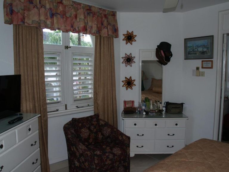 Habitación con tocador, espejo y sillón del Sandcastles Resort en Ocho Rios, Jamaica