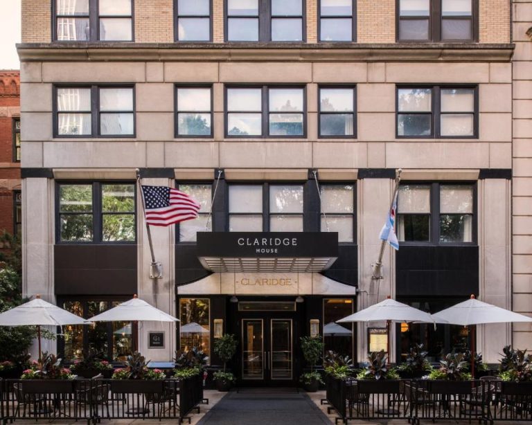 Fachada exterior del Claridge House Chicago con terraza al aire libre y banderas en la entrada principal