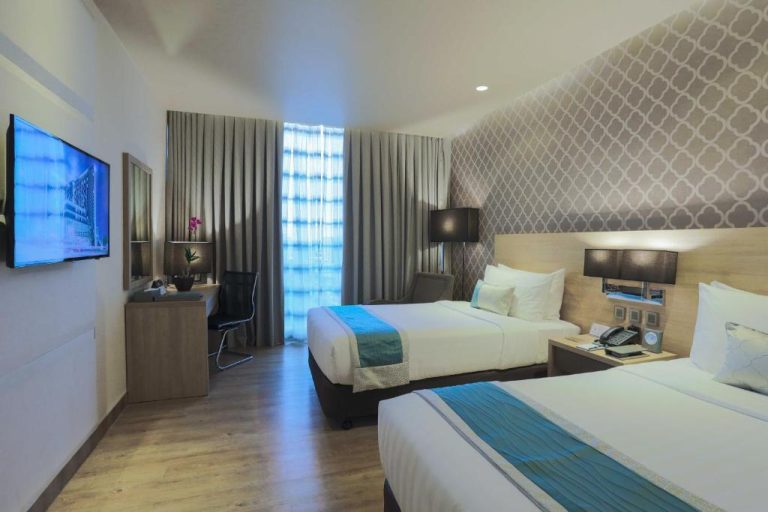 Habitación twin moderna con dos camas y decoración elegante en bai Hotel Cebu, Filipinas