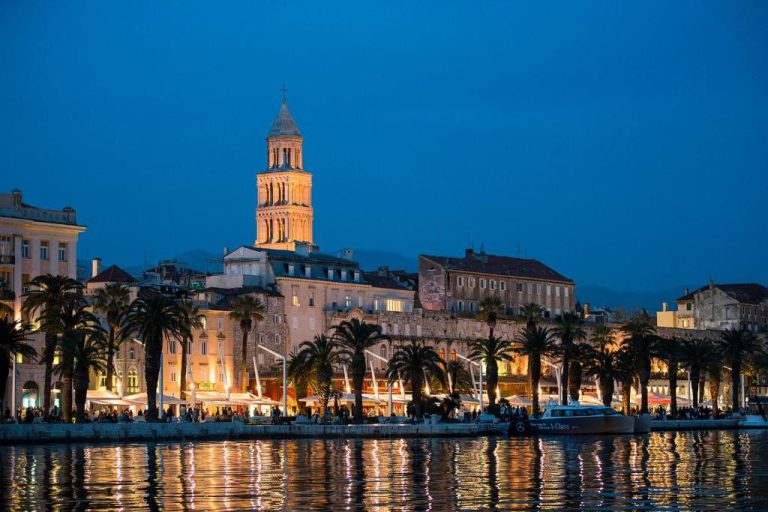 Vista nocturna del Heritage Hotel Antique Split con catedral iluminada y paseo marítimo con palmeras