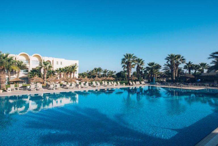 Piscina exterior con tumbonas y palmeras del Iberostar Waves Mehari Djerba en Túnez