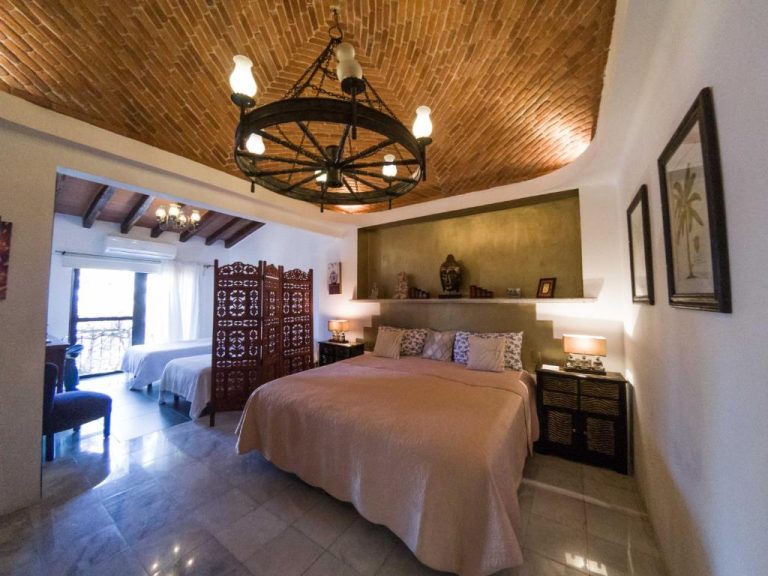 Habitación doble con techo de ladrillo y lámpara de rueda en La Villa du Golf à Cancun Hotel Boutique