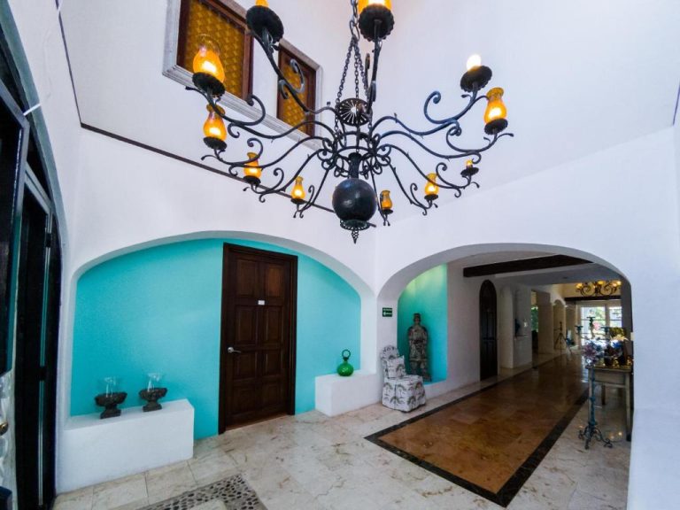 Lobby colonial con lámpara de hierro forjado y arcos en La Villa du Golf à Cancun Hotel Boutique