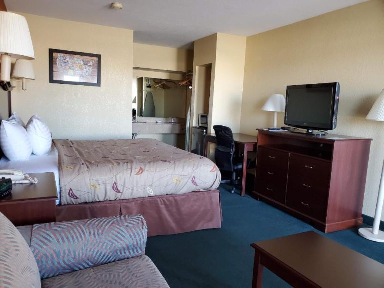 Habitación amplia con cama king size, televisor y escritorio de trabajo en el Cuba Inn Hotel